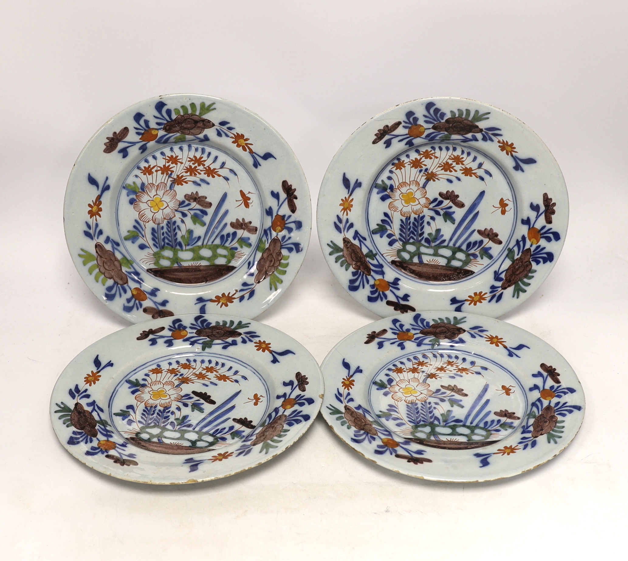 A set of four mid 18th century Delft polychrome floral plates, 22.5cm diameter